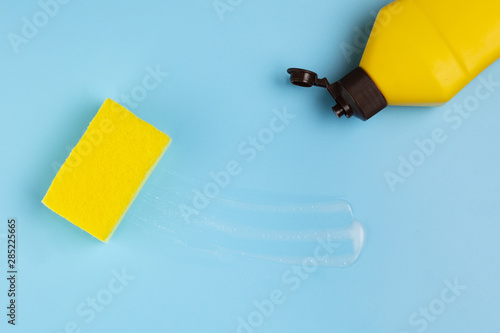 Flat lay yellow detergent bottle and sponge photo