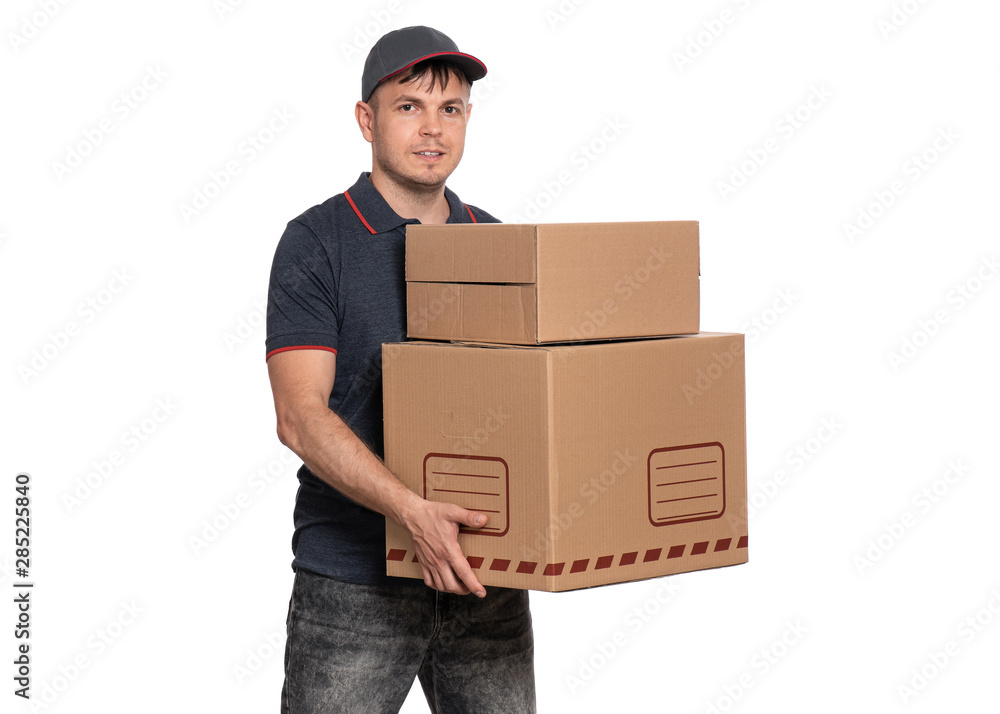 Portrait of Delivery man in cap holding big cardboard boxes. Handsome man looking on camera. Courier isolated on white background. Portrait of Delivery man in cap holding big cardboard boxes. Handsome man looking on camera. Courier isolated on white background.