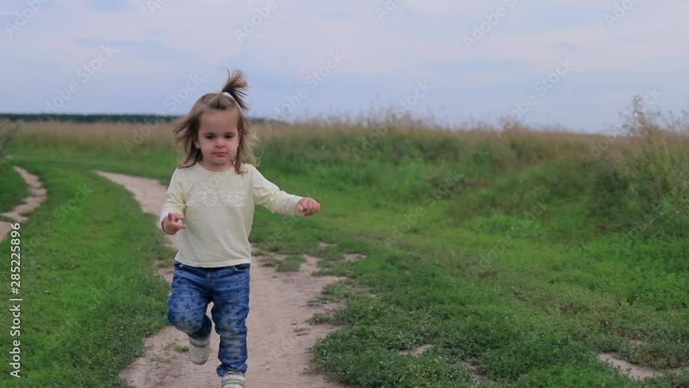 Happy laughing baby girl running in a clover field Happy laughing baby girl running in a clover field