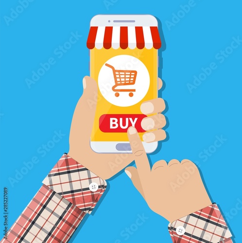 mobile payment concept. Internet shopping concept. E-commerce concept. Shopping online human hand holding mobile phone with shopping cart and buy button on the screen