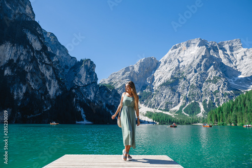Happy young woman on the wooden pier , mountain lake beautiful view with blue sky at sunny day