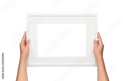White frame. Woman hanging a frame on the wall. Empty frame template.