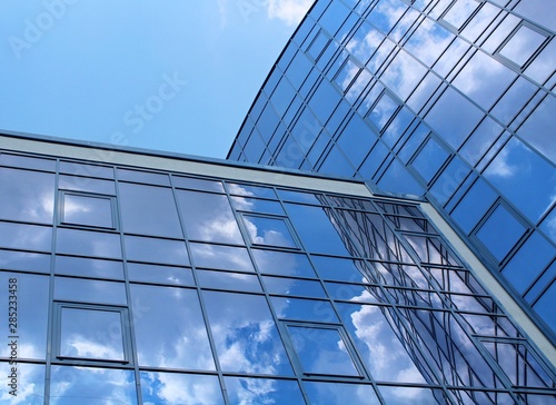 clouds reflected in the many mirrored facets of a modern office building