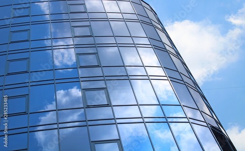 clouds reflected in the many mirrored facets of a modern office building