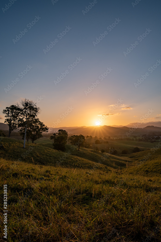 As the sun sets it casts beautiful colours and shadows across the farm fields and landscape of Murwillumbah, NSW, Australia As the sun sets it casts beautiful colours and shadows across the farm fields and landscape of Murwillumbah, NSW, Australia