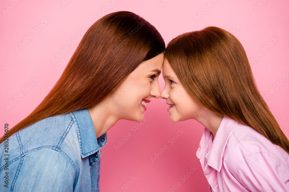 Close up profile side photo of lovely girls smiling wearing denim jeans shirt isolated over pink background Close up profile side photo of lovely girls smiling wearing denim jeans shirt isolated over pink background
