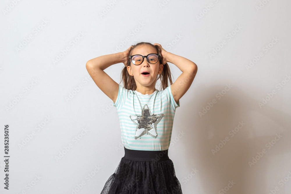 The little girl is happy. Child holding his head The little girl is happy. Child holding his head