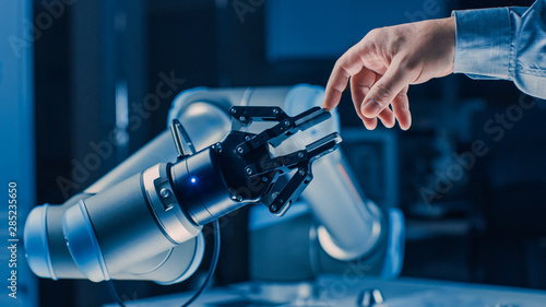 Futuristic Robot Arm Touches Human Hand in Humanity and Artificial Intelligence Unifying Gesture. Conscious Technology Meets Humanity. Concept Inspired by Michelangelo's Creation of Adam photo
