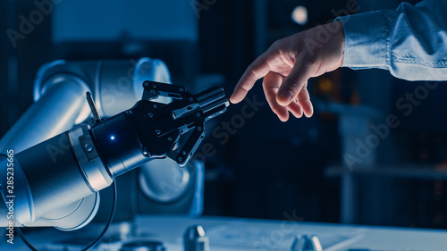 Futuristic Robot Arm Touches Human Hand in Humanity and Artificial Intelligence Unifying Gesture. Conscious Technology Meets Humanity. Concept Inspired by Michelangelo's Creation of Adam