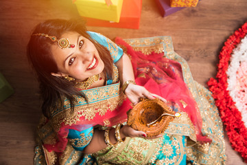 beautiful indian girl holding diya on diwali festival night, top view.selective focus