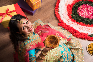 beautiful indian girl holding diya on diwali festival night, top view.selective focus