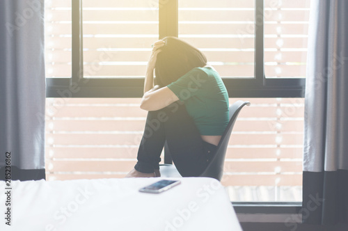 Fotografie Woman disappointed in life while sitting on chair in bedroom,Suicide prevention,