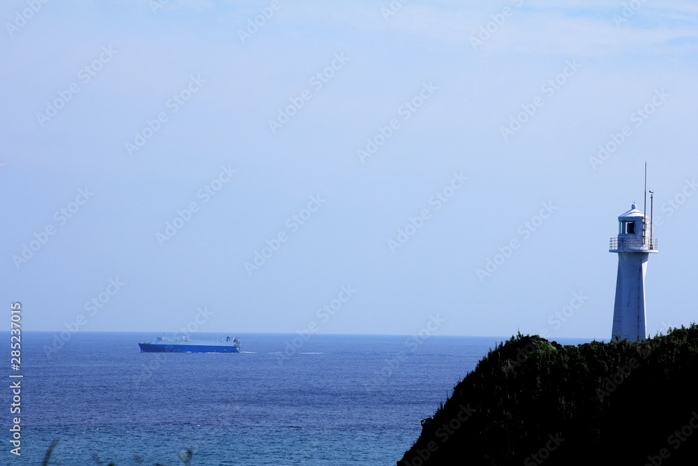 足摺岬灯台と出航する大型船