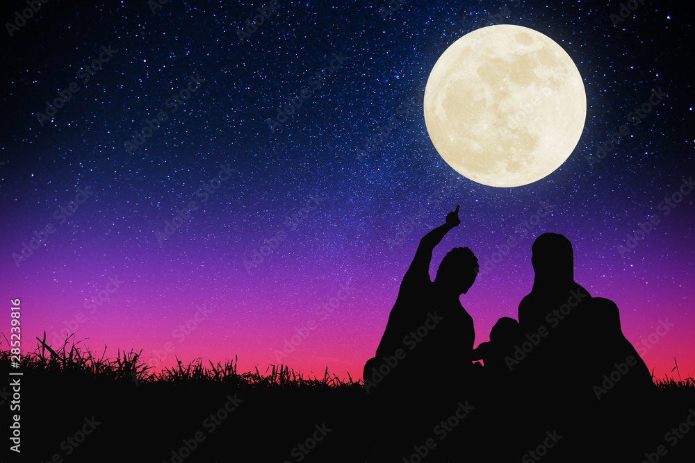 happy family sitting on hill and watching the moon and star .Celebrate Mid-autumn festival happy family sitting on hill and watching the moon and star .Celebrate Mid-autumn festival