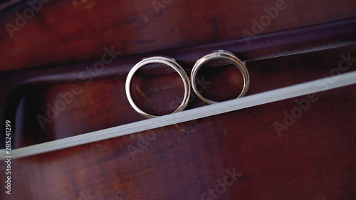 Gold Wedding Rings macro closeup on bow for violin on a musical instrument diamon Jewellery