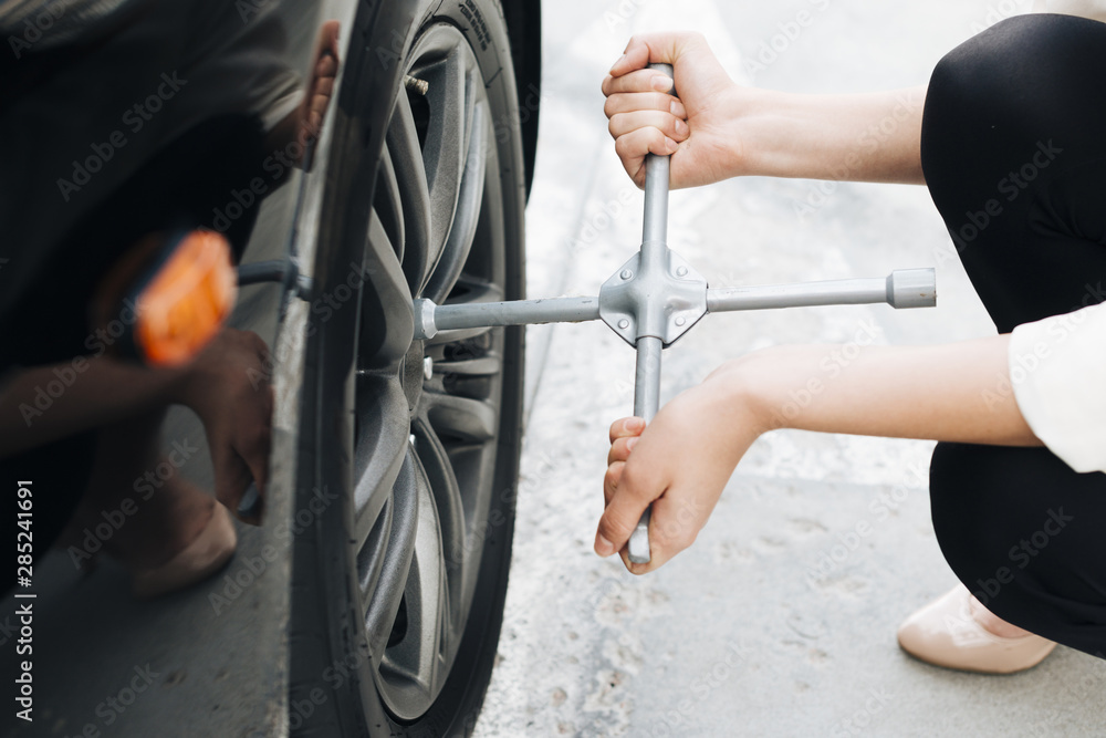 Close-up of woman changing tire