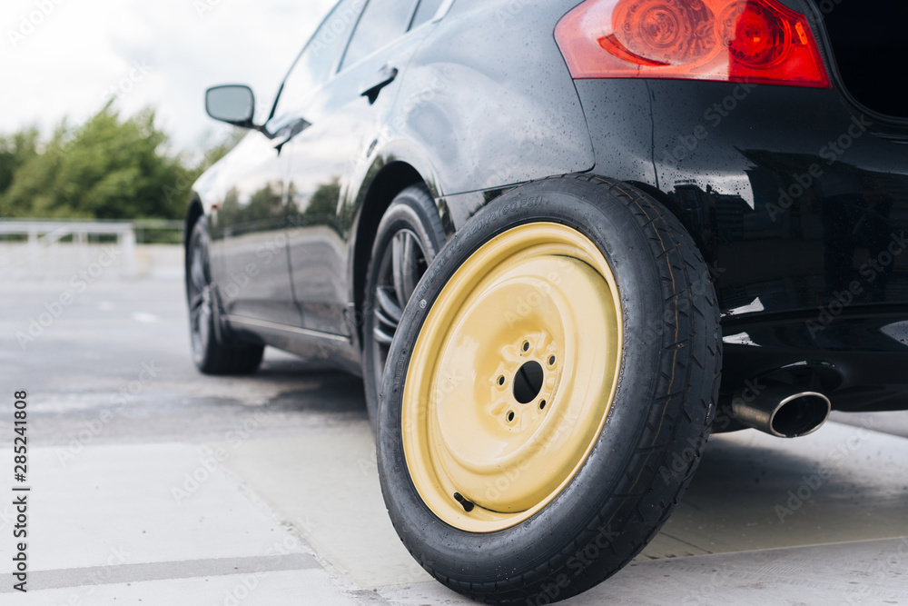 Naklejka premium Car with spare tier propped on