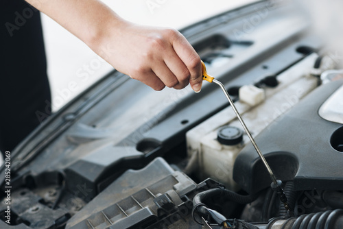 Close-up of woman checking oil