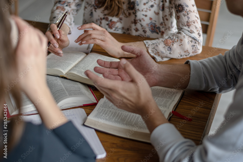 Obraz premium Christian worship and praise. Happy friends praying and reading the bible together.