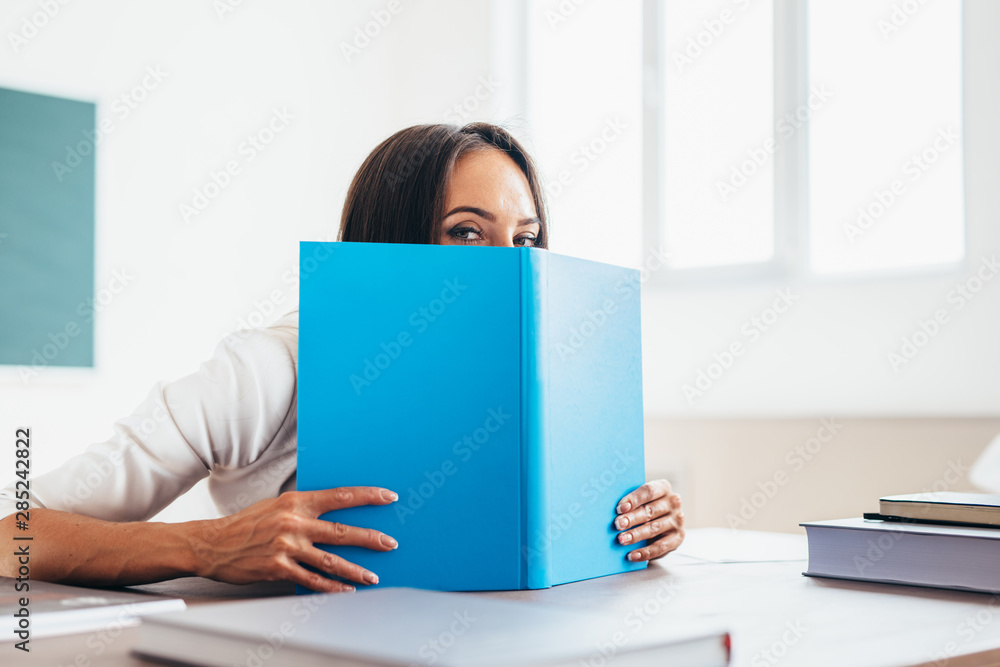 Lovely girl student hiding behind the book Lovely girl student hiding behind the book