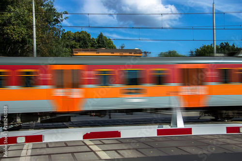 Obraz na plátně Fast moving train, blurred motion. Level crossing.