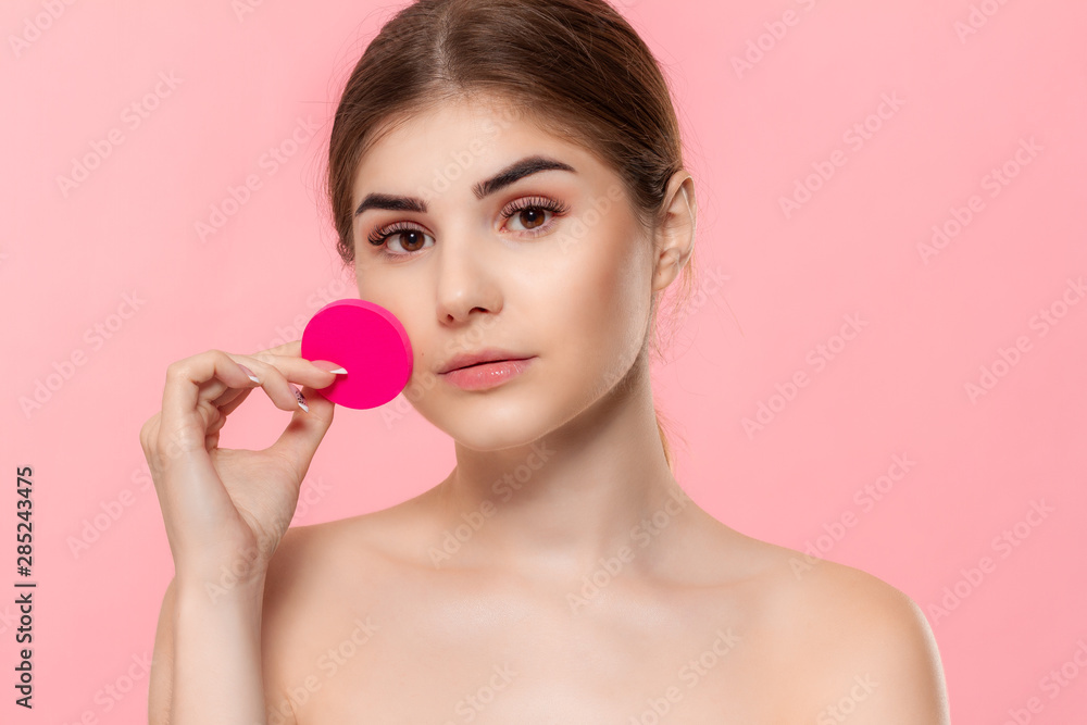 Beautiful model holds cotton sponge close to face. Beautiful model holds cotton sponge close to face.