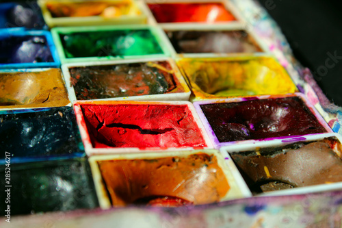 Blurred image of watercolor pallet. Art materials, hobby concept. Palette of colors, close up.