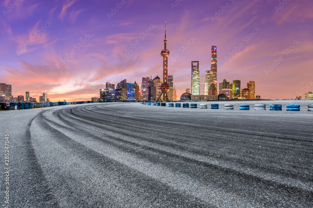 Shanghai skyline and modern buildings with empty race track at sunrise,China.