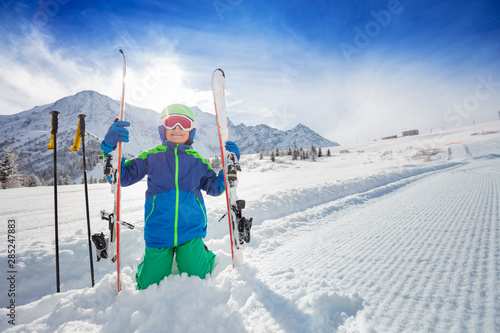 Obraz na plátně Portrait of a boy sit in snow with ski on slope