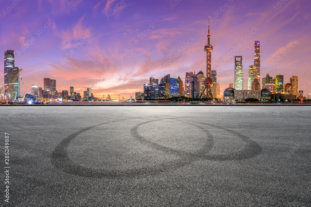Shanghai skyline and modern buildings with empty race track at sunrise,China.