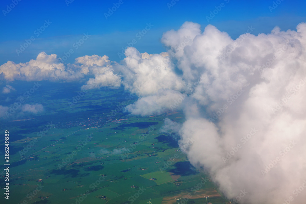Fototapeta premium flight through the clouds and over green fields 