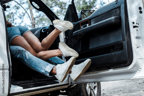 cropped view of young man and woman making out in modern car photo