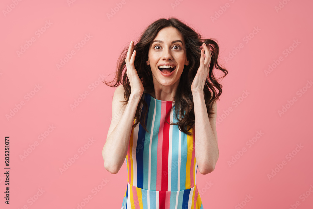 Shocked surprised positive cute woman posing isolated over pink wall background.