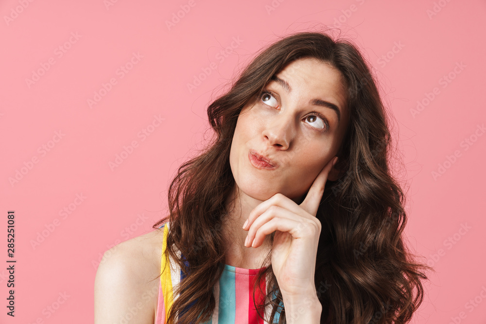 Fototapeta premium Thinking cute woman posing isolated over pink wall background.