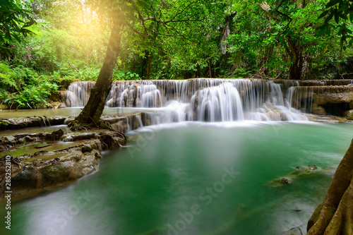 Beautiful waterfall in tropical forest with warm sunshine.