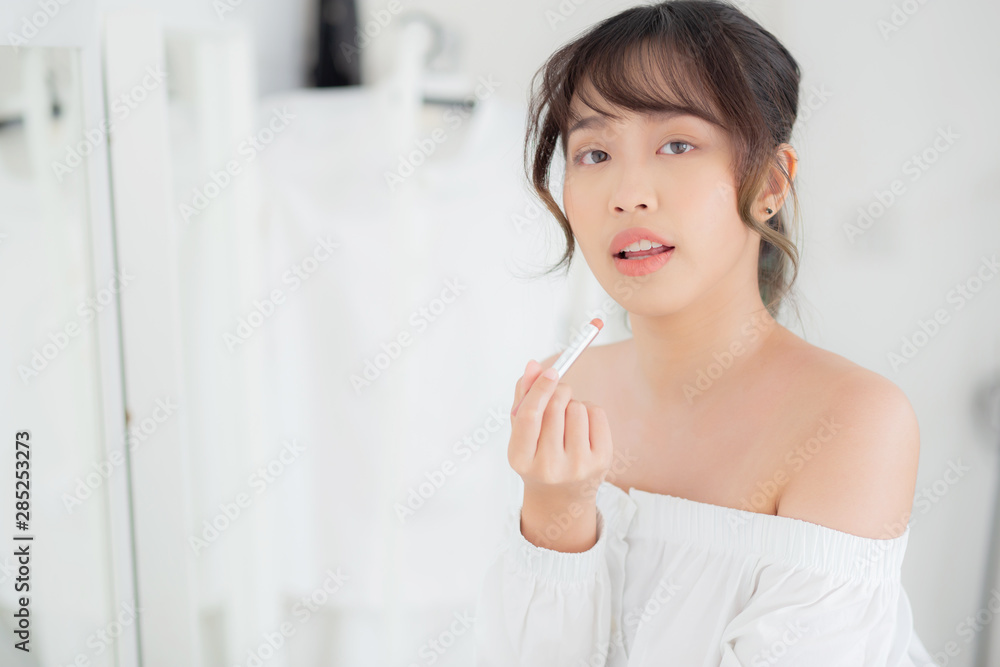 Beautiful portrait young asian woman looking mirror applying makeup lipstick at room, beauty lips asia girl makeup and cosmetic fashion on mouth at home, lifestyle and health care concept. Beautiful portrait young asian woman looking mirror applying makeup lipstick at room, beauty lips asia girl makeup and cosmetic fashion on mouth at home, lifestyle and health care concept.