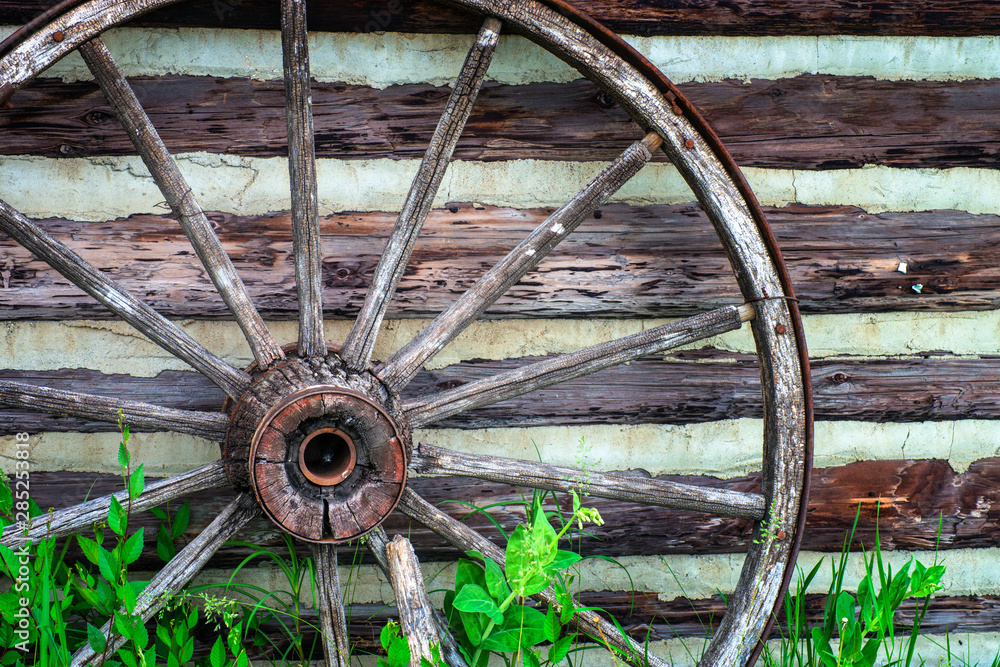 Vintage Wagon Wheels Leaning Against Log Building