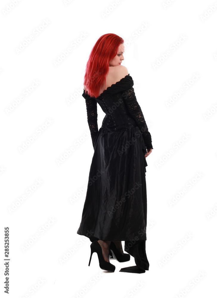 full length portrait of a red haired girl wearing a black gothic gown, Standing pose on a grey studio background. full length portrait of a red haired girl wearing a black gothic gown, Standing pose on a grey studio background.