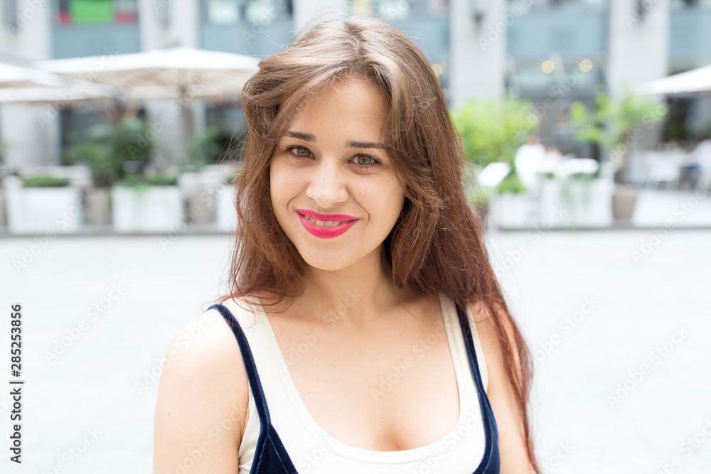 Portrait of a beautiful brunette woman on a background of a city street and cafe. Portrait of a beautiful brunette woman on a background of a city street and cafe.