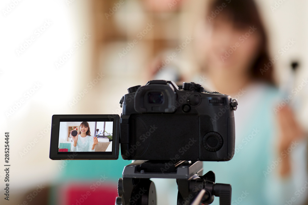 blogging, technology and videoblog concept - camera recording video blog of happy smiling asian beauty blogger with make up cosmetics at home blogging, technology and videoblog concept - camera recording video blog of happy smiling asian beauty blogger with make up cosmetics at home
