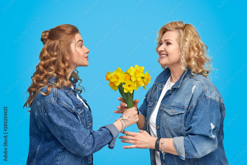 Daughter giving flowers to mother Daughter giving flowers to mother