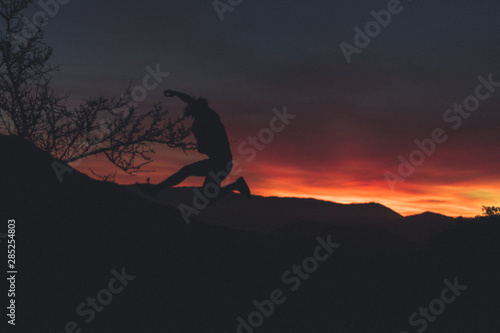 man traveling the world, enjoying the sunset, jumping