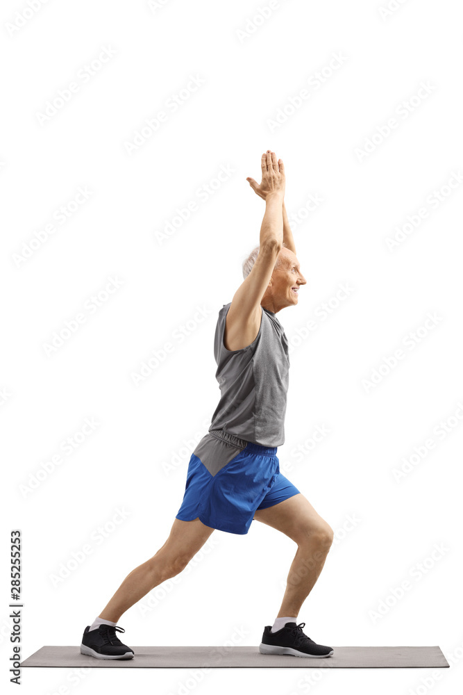 Senior man practicing yoga pose on an exercise mat Senior man practicing yoga pose on an exercise mat