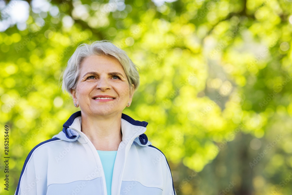 fitness, sport and healthy lifestyle concept - smiling sporty senior woman at summer park fitness, sport and healthy lifestyle concept - smiling sporty senior woman at summer park