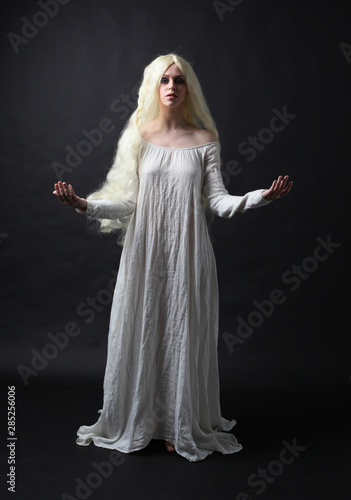 Obraz na plátně Ghostly full length portrait of a woman with long blonde hair wearing a white robe