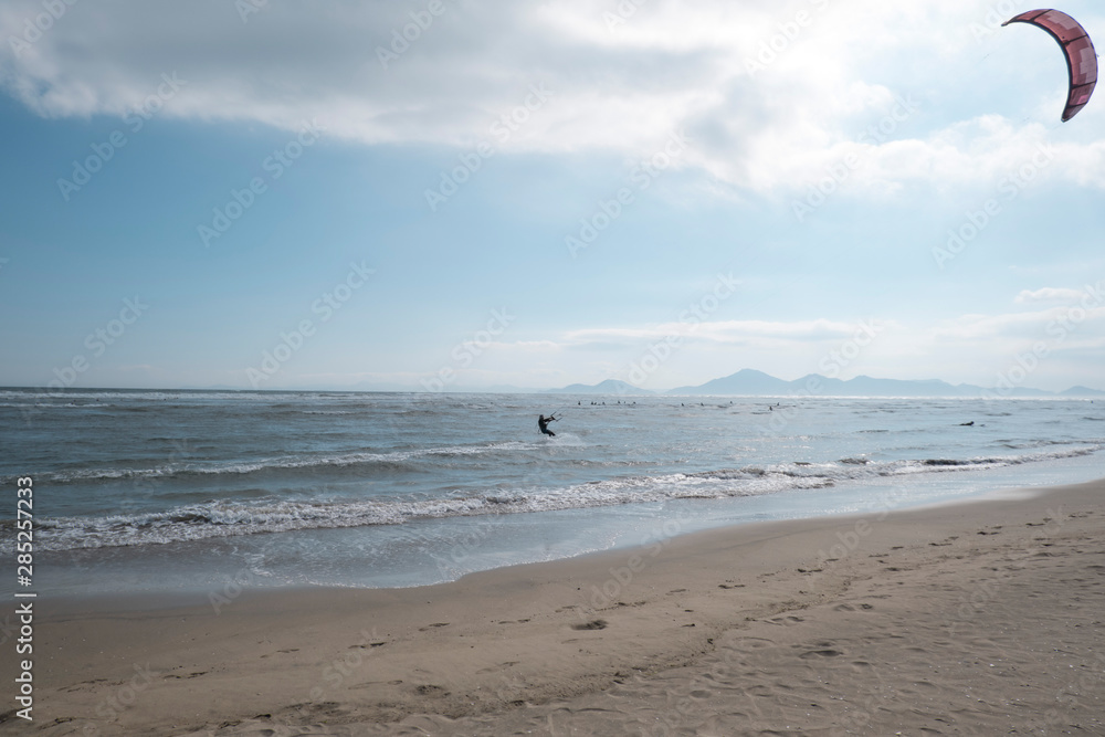 A man engaged in kitesurfing during the day