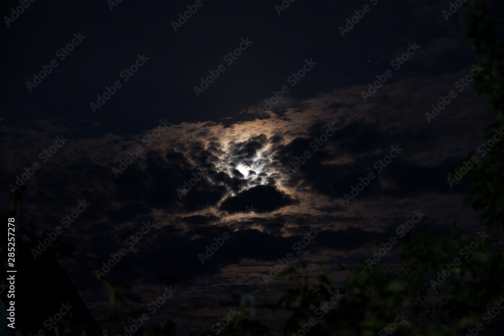 Obraz premium moon in the black sky peeps out of the clouds