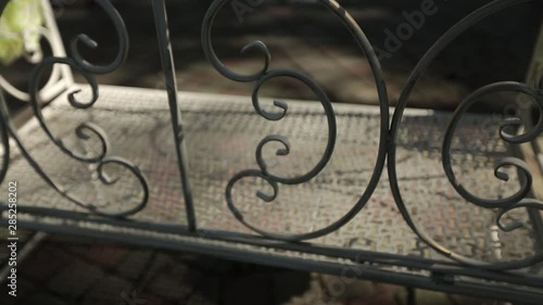 Old iron bench in the sunny summer rays