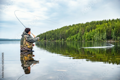 Foto Fisherman using rod fly fishing in mountain river