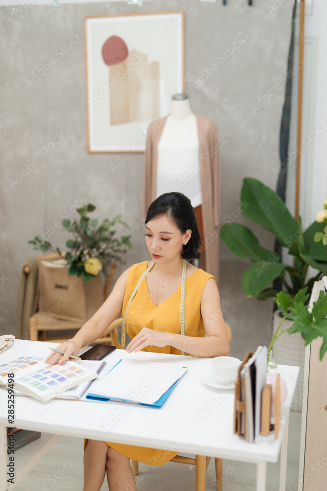 A young fashion designer working on her atelier A young fashion designer working on her atelier